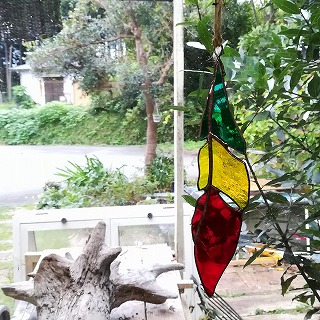 赤、黄色、緑色の羽根のステンドグラス