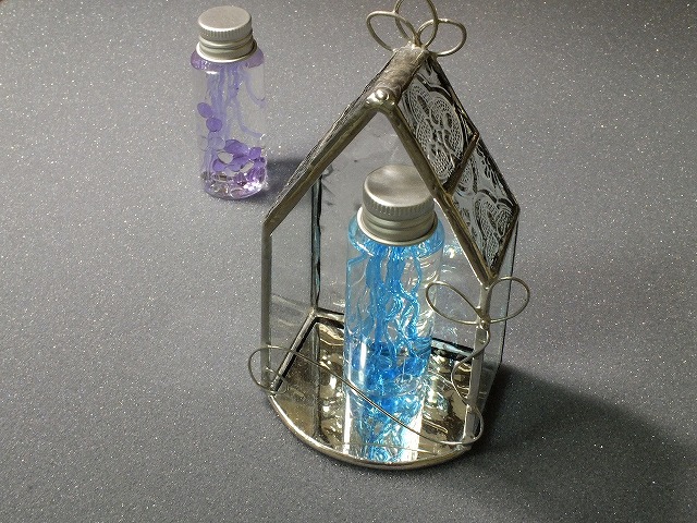 ステンドグラスミニハウスに収まった紫色のガラスのミニボトル